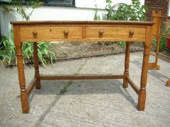 Heals of London. An oak Arts and Crafts Cotswold style two drawer desk - Thumbnail 1