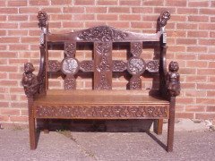 A Celtic Arts and Crafts carved oak settle with carved dragons to the tops - Thumbnail 1