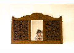 Arthur Simpson. An Arts Crafts mirror with shaped top, the central bevelled mirror, flanked by stylised carved floral details. - Thumbnail 1
