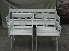 A pair of successionist cast iron garden seats with a matching four seater bench. - Thumbnail 1