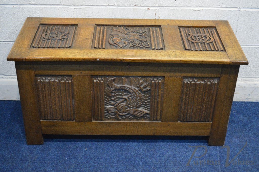OAK_BLANKET_CHEST_with_linenfold_panels_to_all_sides_carved_dragons_to_the_top_and_front_date_reading_1938_two_initials_to_the_lid_width_112cm_x_depth_46cm_x_height_56cm_master