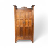 Shapland & Petter. An Arts & Crafts Oak Hall Cupboard with a Ruskin Circular Jewel