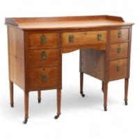 Waring & Gillow. An Arts & Crafts Bow Fronted Kneehole Twin Pedestal Desk