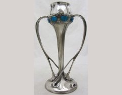Liberty and Co. A Tudric Pewter and Enamel organic vase with blue/green enamel roundels to the top and twin whiplash handles. - Thumbnail 1