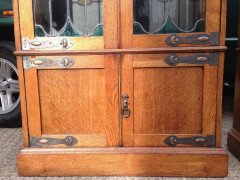 A pair of Arts and Crafts oak glazed bookcases over a lower cupboard - Thumbnail 3