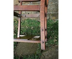 An Arts and Crafts Cotswold School armchair with lower shelf and pierced floral detail - Thumbnail 4