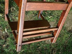 An Arts and Crafts Cotswold School armchair with lower shelf and pierced floral detail - Thumbnail 5